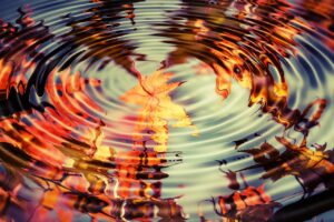 Ripple in water with autumn leaves in reflection